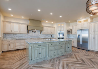 light kitchen with marble topped center island and chevron floor